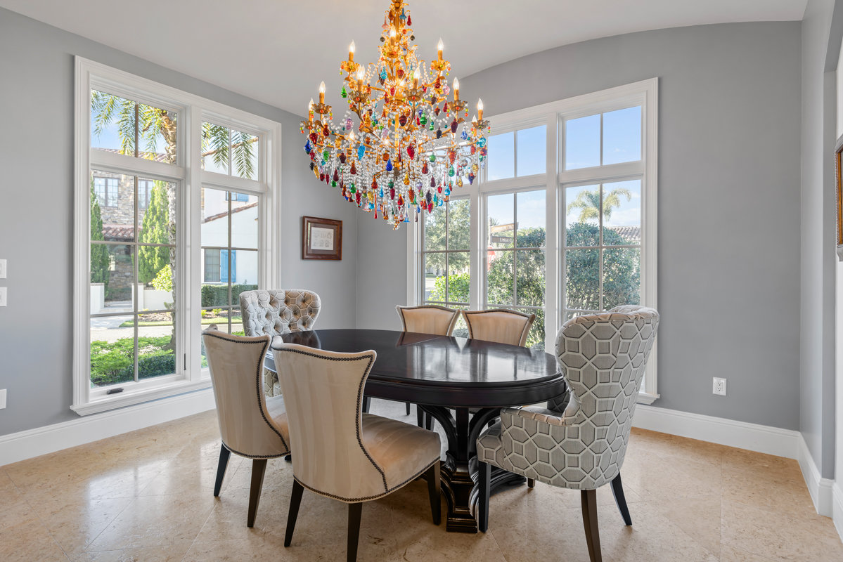 dining space with colorful glass chandelier and dark wood table